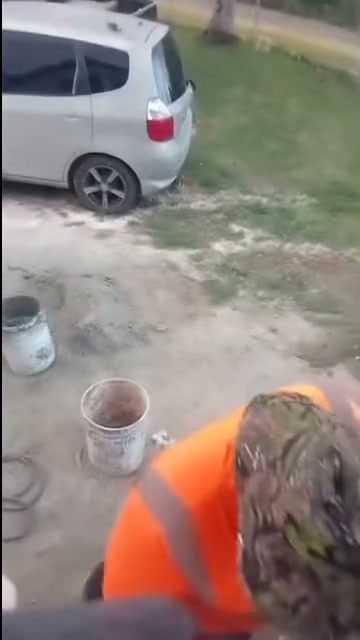 Crew member in a hi-vis vest working on site beside mortar buckets