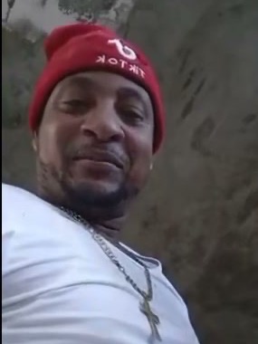 Spugie on a job site in a red TikTok beanie and white work shirt