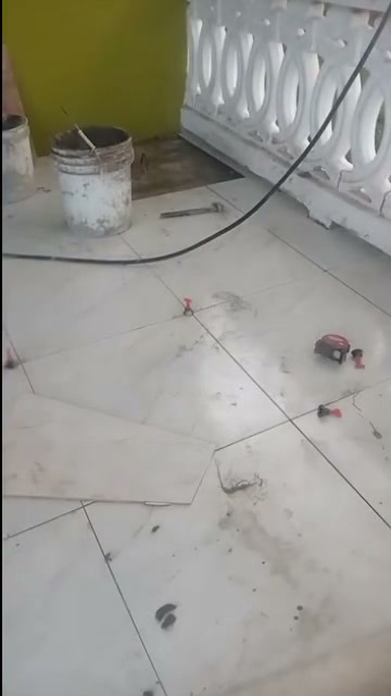 Large white floor tiles being laid on a balcony with levelling clips in place